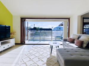 黄金海岸Waterfront Haven Balinese Villa at Bundall的带沙发和电视的客厅