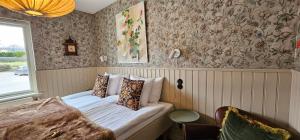 布勒萨普布罗萨捷斯提芙丽酒店暨SPA的壁纸客房内的一间卧室配有一张床