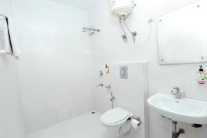 新德里Hotel Mars Meg at Delhi Airport的白色的浴室设有卫生间和水槽。