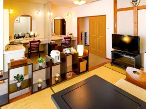 SagaeHotel Symphony Sagae Onsen的带电视的大客厅和客厅。