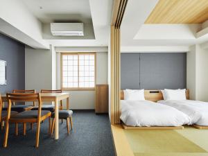 大阪MIMARU OSAKA SHINSAIBASHI WEST的卧室配有一张床和一张桌子及椅子