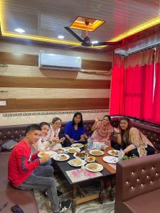 阿格拉Friends Guest House & Hostel- near TAJ MAHAL的一群坐在桌子旁吃饭的人