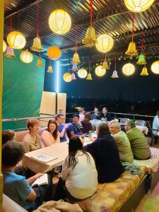 阿格拉Friends Guest House & Hostel- near TAJ MAHAL的一群人坐在一个房间里桌子旁