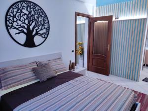 托尔托纳Appartamento centrale的卧室配有一张床铺,墙上挂着一幅树景