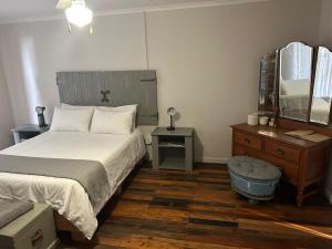 布隆方丹Oudam Overnight Accomodation的一间卧室配有一张床、梳妆台和镜子