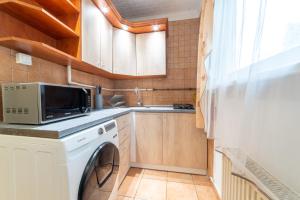 米什科尔茨Comfort 28 B的厨房配有洗衣机和水槽
