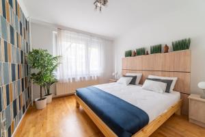 米什科尔茨Comfort 28 B的一间卧室配有一张大床和盆栽植物
