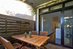 悉尼Spacious 3 Bedroom House Glebe with 2 E-Bikes Included的天井上的木桌和椅子