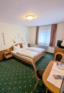 巴特黑雷纳尔布费德里塔斯酒店的酒店客房带一张床、一张桌子和椅子