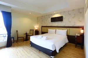 莱卡邦素万那普威乐机场酒店的卧室设有一张白色大床和一扇窗户。