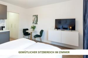 拜罗伊特Apartment Wahnfried No5 - zentrales Cityapartment Küche mit Duschbad - 300m zur Fussgängerzone的一间卧室配有一张床和一台平面电视