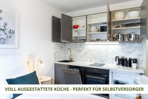 拜罗伊特Apartment Wahnfried No5 - zentrales Cityapartment Küche mit Duschbad - 300m zur Fussgängerzone的厨房配有水槽和炉灶