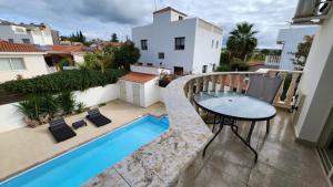 Anarita2-bedroom Villa with private pool in Anarita Paphos的一个带桌子和游泳池的阳台