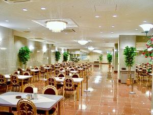 米子市Yonago Universal Hotel的餐厅内带桌椅的用餐大厅