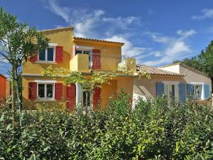 博尔戈Lovely apartment in Borgo with shared pool的黄色的房屋,有红色的百叶窗和树木