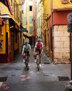 博索莱伊Penthouse over Monaco的两个人骑着自行车沿着城市街道