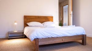 普瓦捷Le Moulin du Clain - Jolie maison à Poitiers的一间卧室配有一张带木制床头板和镜子的床