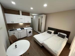 巴统HOTEL PARIS的带两张床和一张桌子的房间以及一间厨房