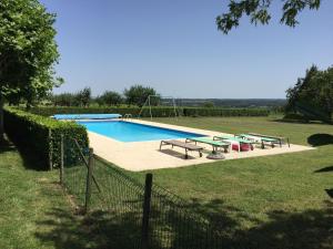 BourréCharming Holiday Home in Montrichard with Pool的庭院内带桌子和长椅的游泳池