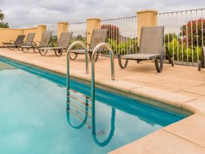 圣耐克森Modern holiday home in Aquitaine的游泳池旁的一排椅子