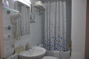 罗列特海岸Hostal - Pensión El Amigo的一间带水槽、卫生间和淋浴的浴室