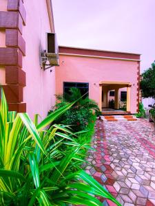 巴加莫约Family Ties的前面有植物的粉红色建筑