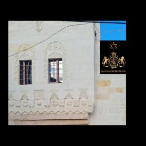 阿瓦诺斯KING SOLOMON PALACE的一座建筑,上面有两扇窗户和标志