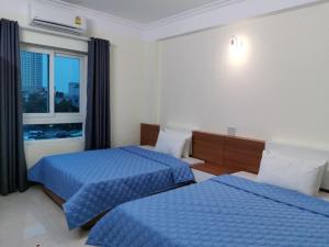 格卢市社Sóng Biển Hotel Cửa Lò的酒店客房设有两张床和窗户。