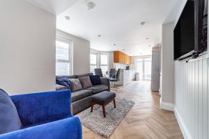 伦敦Amazing 2BR flat wprivate garden, Maida Vale的客厅配有蓝色的沙发和电视