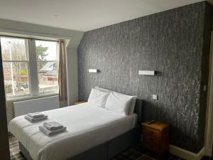 因弗内斯Crown Hotel & Bar的一间卧室配有一张床,上面有两条毛巾