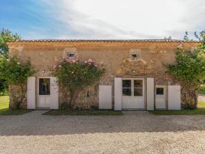 CampsegretRestored farmhouse with private pool的一座石头建筑,有白色的门和鲜花