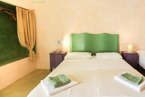 帕拉比塔Luna e Basilico by Casa di Marco的一间卧室设有两张床和绿色床头板