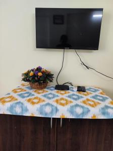 科钦1 BHK Flat in Kochi 904的电视机顶部的桌子和花盆
