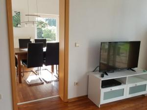 东贝沃恩Holiday apartment Aufderhaar的客厅配有电视和桌椅