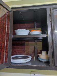 科钦1 BHK Flat in Kochi 904的装满盘子、碗和盘子的橱柜