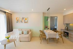 头顿The Song Apartment - CONDOTEL BUNNY HOME VUNG TAU的厨房以及带桌子和沙发的客厅。