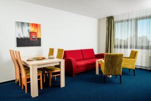 斯塔利斯莫克维克斯莫克维克家庭公寓酒店的客厅配有红色的沙发、桌子和椅子