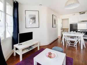 滨海伊西尼Attractive Apartment in Isigny sur Mer near Centre的客厅配有电视和桌子