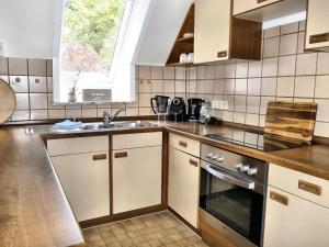 AumühleHoliday apartment Green House的厨房配有水槽和炉灶 顶部烤箱