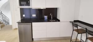 莱里达SM Apartments的白色的厨房配有水槽和微波炉