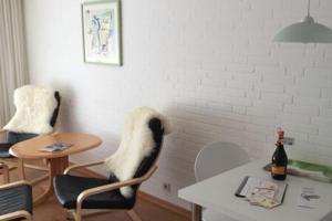 韦斯特兰Apartment in Westerland的客厅配有桌子、椅子和桌子