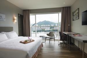 峇六拜槟城橄榄树酒店的配有一张床、一张书桌和一扇窗户的酒店客房