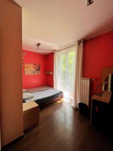 克拉科夫Cosy room Aleja Kijowska的卧室设有红色的墙壁和一张带窗户的床