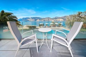马尔切西内卡普里酒店的阳台配有桌椅,享有水景。