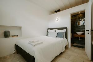利马索尔Smaragda's Guest Rooms的一间带白色大床的卧室和一间浴室
