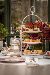 马德里Relais & Châteaux Hotel Orfila的茶壶桌子上的食物盘