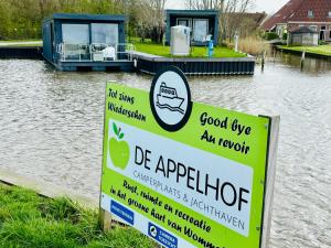 WommelsUniek overnachten in een Tiny House op de Appelhof的船在水体旁边的一个标志