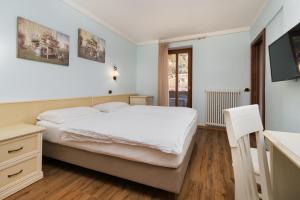圣洛伦佐因巴纳莱Hotel Opinione Dimora Storica的卧室配有白色的床和电视。