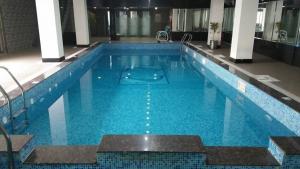锡亚尔科特Javson Airport Hotel的大楼内一个蓝色的大型游泳池
