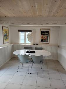 NyordRagnhilds Gård, Hostel的一间配备有白色桌椅的用餐室